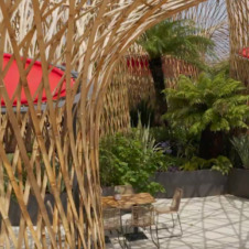 Röhrenartige, große Strukturen aus Bambus, dazwischen ein Tisch mit Stühlen | Pavillons & Event-Überdachungen aus Bambus für Events