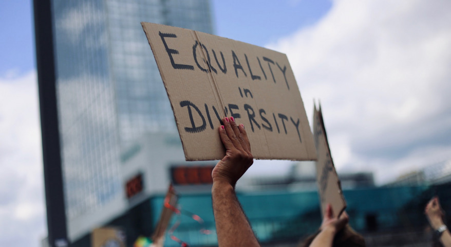 Symbolbild für Gleichberechtigung: Arm hält Pappschild hoch, darauf steht "Equality in Diversity"