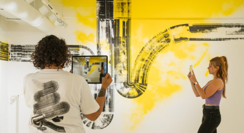 Menschen, die sich ein AR Kunstwerk auf Tablets anschauen - Jazzunique Showroom