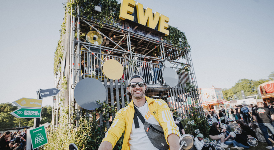 Mann vor dem vollen EWE Festival-Kraftwerk | Ein Marken-Stand und Praxistest für nachhaltige Energielösungen auf Festivals